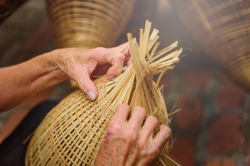 Vietnamese fishermen are doing basketry for fishing equipment at morning in Thu Sy Village, Vietnam.
