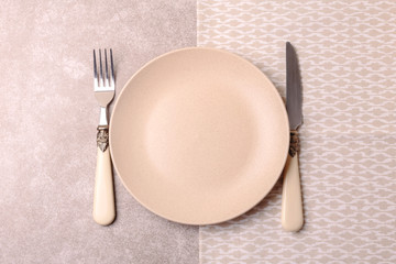 Empty vintage ceramic plate, cutlery, napkin. Top view, copyspace.