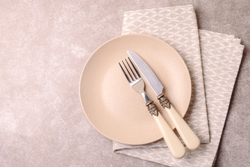 Empty vintage ceramic plate, cutlery, napkin. Top view, copyspace.