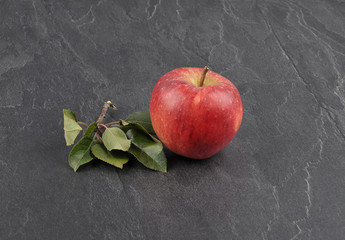 Apfel mit Blättern auf Schiefer