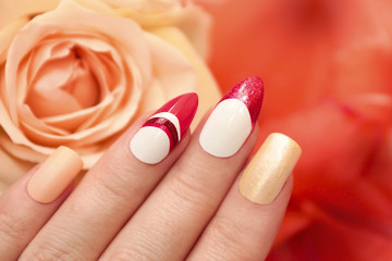Multi-colored pastel nail design for different square and oval shaped nails on female hand close up.