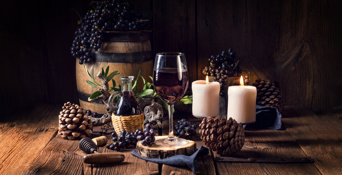Red wine from a barrel with grapes and a glass of wine