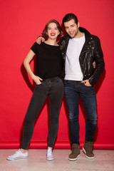 Full length image of happy punk couple hugging