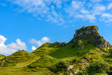Tourist hiking the Mystic Fairy Glen, a romantic green valley in the Isle of Skye.