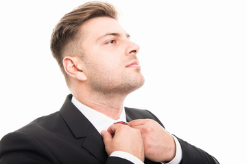 Close-up of handsome business man standing arranging his collar