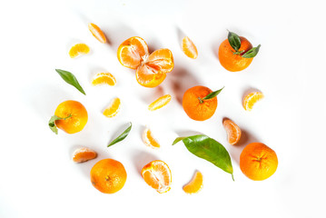Fresh tangerines, with leaves, whole and broken into pieces, pattern, on white background, top view copy space isolation