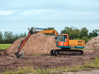 Fototapeta na wymiar Excavator Against Pile Of Dug Earth