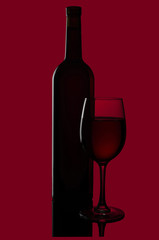 Bottle of red wine from a green glass and a glass of red wine isolated on red background