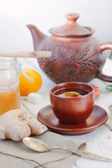 Nice ginger tea on white wooden surface.