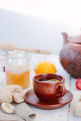 Nice ginger tea on white wooden surface.