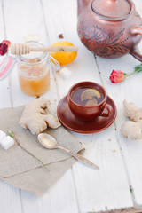 Ginger tea with lemon, lime and honey on white.