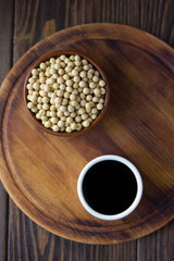 Soy sauce in a white ceramic bowl over wooden board.