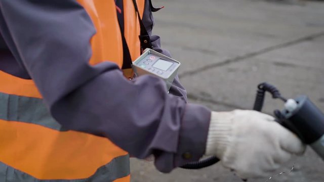 Anonymous man using special warning device to check radiation level