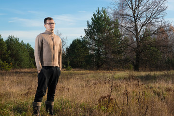 A man in rubber boots is standing in nature. The concept of outdoor recreation.