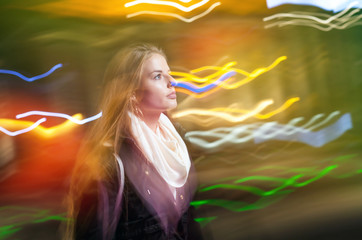 Obraz na płótnie Canvas Woman in city at night among neon moving lights