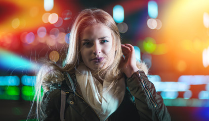 Night portrait of young girl in colorful city lights