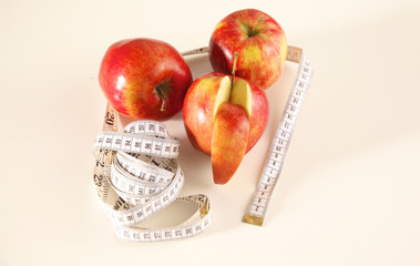 apple lying on a table with a stethoscope and measuring tape