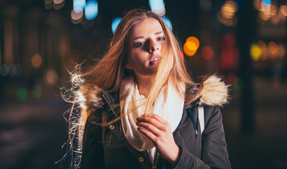 Night portrait of young girl in colorful city lights