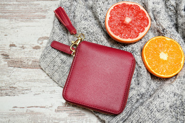 Fototapeta na wymiar Little red female purse and citrus on a sweater. Fashionable concept.