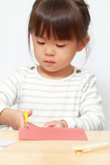 はさみで紙を切る幼児(3歳児)