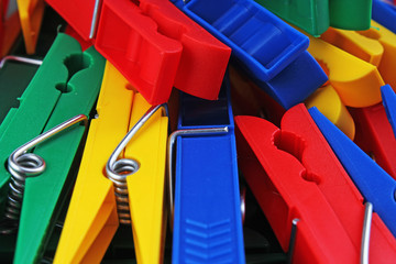 Colorful forecaps tweezers clips as background. Clothespin clothes pin colorful clothespeg red yellow blue clothes peg as wallpaper texture pattern.. Rainbow background.