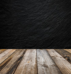 Black stone wall background and wood table