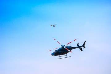 Helicopter and plane fly at blue sky