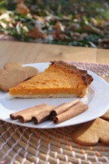 Torta alla zucca e cannella per il giorno del Ringraziamento. Fetta di torta su piatto su tavolo di legno.