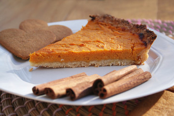 Torta alla zucca e cannella per il giorno del Ringraziamento. Fetta di torta su piatto su tavolo di legno.