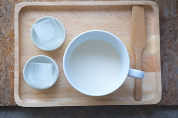Milk in white mug with ice cubes