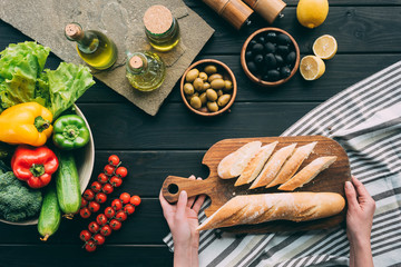 hands holding chopping board with bread