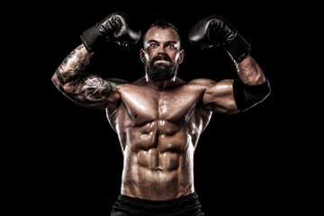 Fototapeta na wymiar Boxer with tattoo in boxing gloves celebrating flawless victory. Sport concept isolated on black background.