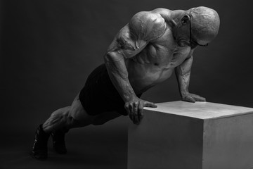 Brutal Strong Athletic Man Bodybuilder posing in studio