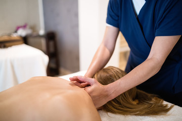 Obraz na płótnie Canvas Masseur treating patient with therapeutic massage