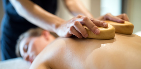 Masseur massaging masseuse at wellness resort