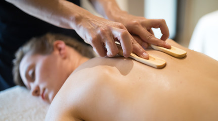 Masseur using wooden accessories to massage