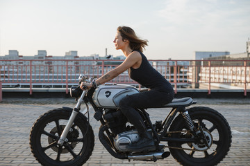 Fototapeta na wymiar pretty young woman ride motorbike on the rooftop