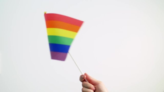 hand waving gay or lgbt pride rainbow colored flag