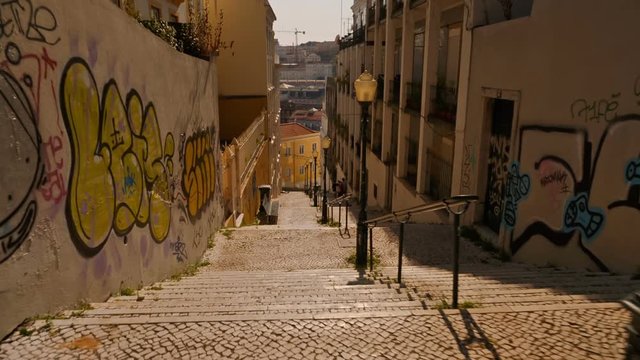 Climbing down the stairs of the famous Calcada do Lavra next to Ascensor do Lavra tram funicular streetcar in Lisbon, Portugal