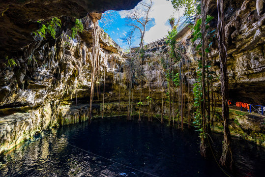 Cenote San Lorenzo Oxman near Valladolid, Yucatan, Mexico. Swimming and relaxing in deep turquoise clear water.