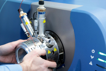 Adjust the mass spectrometer. The man analyzes the device for determining the masses of atoms....