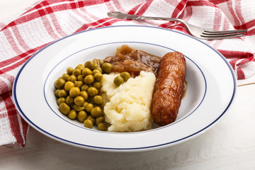banger and mash potato with cooked pea
