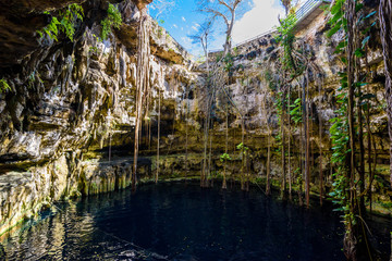 Cenote San Lorenzo Oxman near Valladolid, Yucatan, Mexico. Swimming and relaxing in deep turquoise clear water.