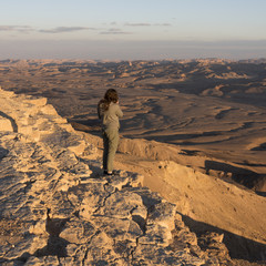 View of teenage girl standing on rock in desert, Makhtesh Ramon, Negev Desert, Israel