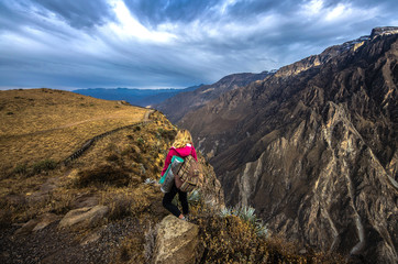 Young woman meditate above the deepest canyon Colca. Panoramic breathtaking view of peruvian...
