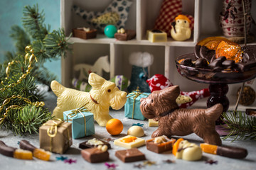 chocolate dogs and candy on light background with Christmas symbols