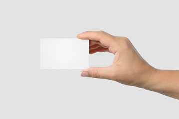 Mockup of female hand holding a Business Card isolated on light grey background. Size 85x 55 mm.
