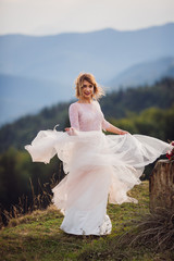 Bride whirls in her beautiful dress before stunning mountain landscape
