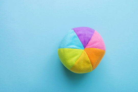 Kids Toys Small Plush Multicolored Textile Soft Ball on Blue Background. Banner Placeholder Charity Nursery Hospital Childhood Concept Copy Space