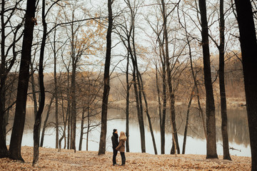 Couple has fun and laughs. kiss. Young hipster couple hugging each other in winter park. Winter love story, a beautiful stylish young couple. Winter fashion concept with boyfriend and girlfriend.